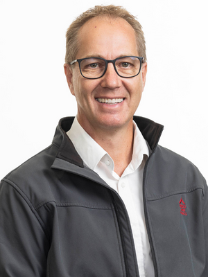 Portrait of man with blonde hair wearing glasses, a grey jacket and white shirt