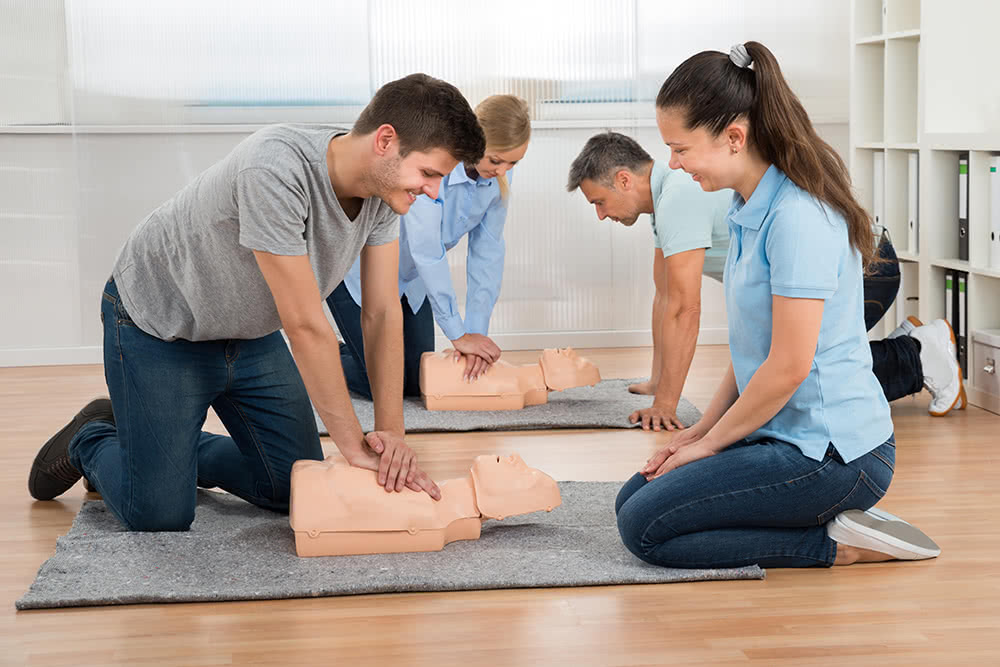 Two young people doing CPR