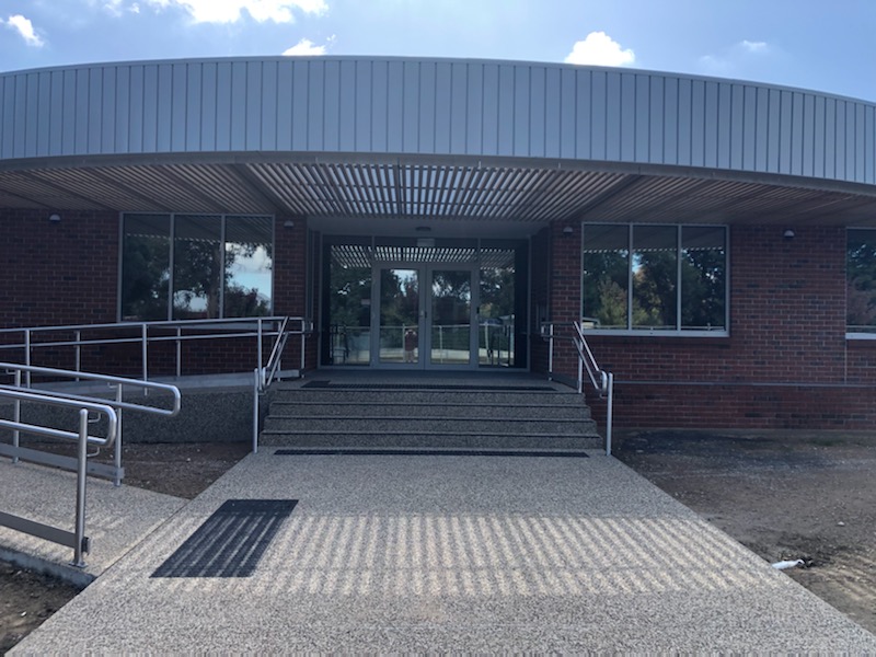 New red brick building with curved roof, footpath and ramp