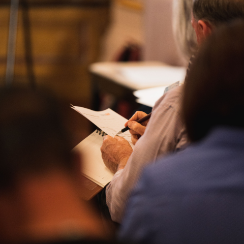 Over the shoulder view of a person writing in a notebook