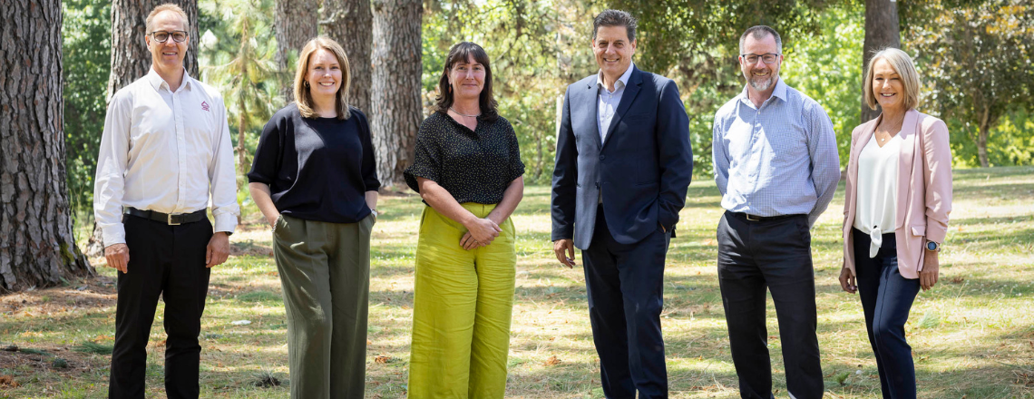 Group photo of executive management team standing in garden