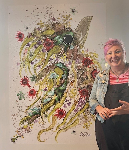 Lisa Bishop with a mural of a kookaburra, the artwork isis colourful and the bird is laughing and happy .jpg